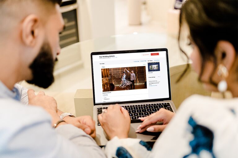 Couple putting drerss code on  wedding website