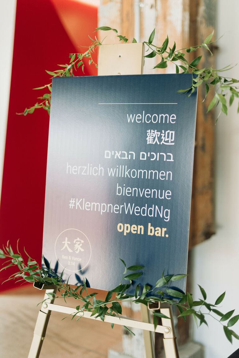Multilingual black sign on easel with greenery