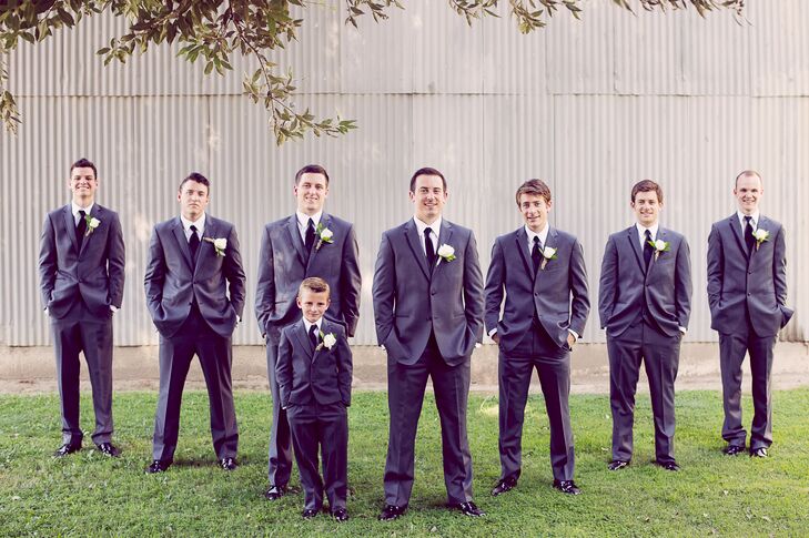 The groom and his groomsmen wore textured charcoal suits by Vera Wang. They chose gray instead of traditional black suits to blend in with the wedding color palette of white, gray and earthy neutrals.
