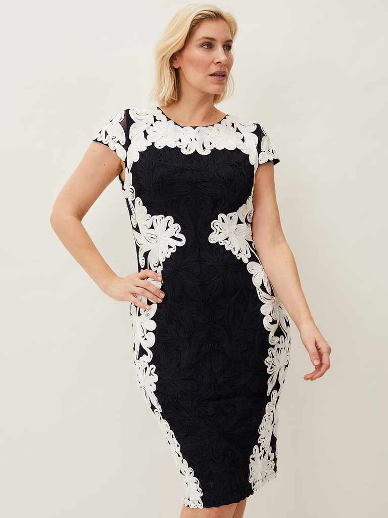 A model shows off this black and white gown with elaborate tapework.