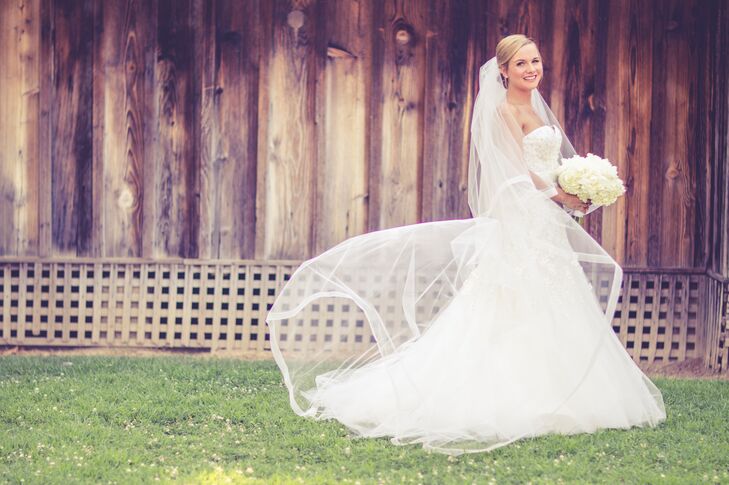 The bride chose a strapless ivory dress by wedding dress designer Liancarlo. It had hand-beaded crystal embroidery that tapered off into a fluttery tool overlay. She paired a long veil with her ivory ball gown.
