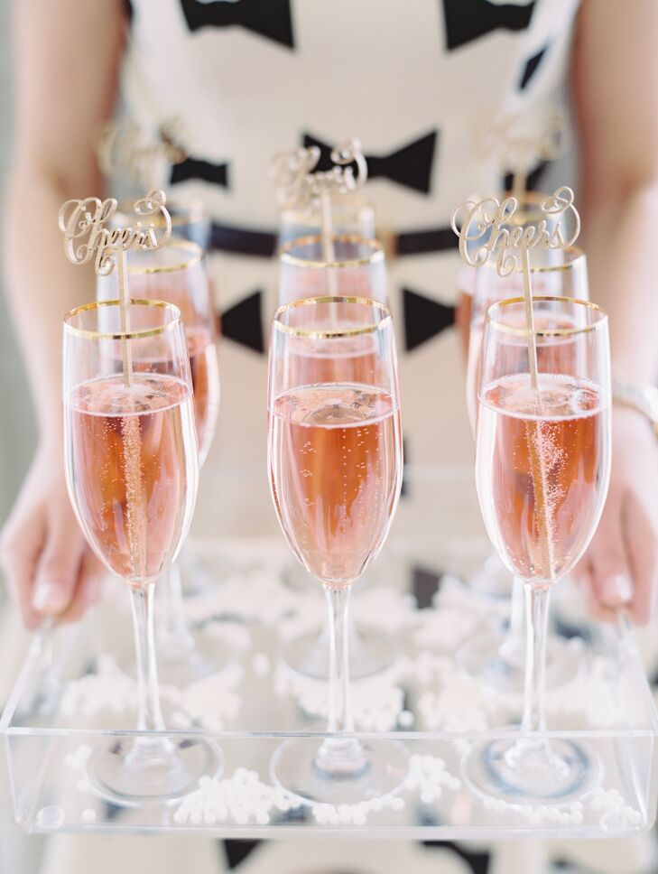 Gold "cheers" drink stirrers added a splash of fun to the glasses of pink champagne.