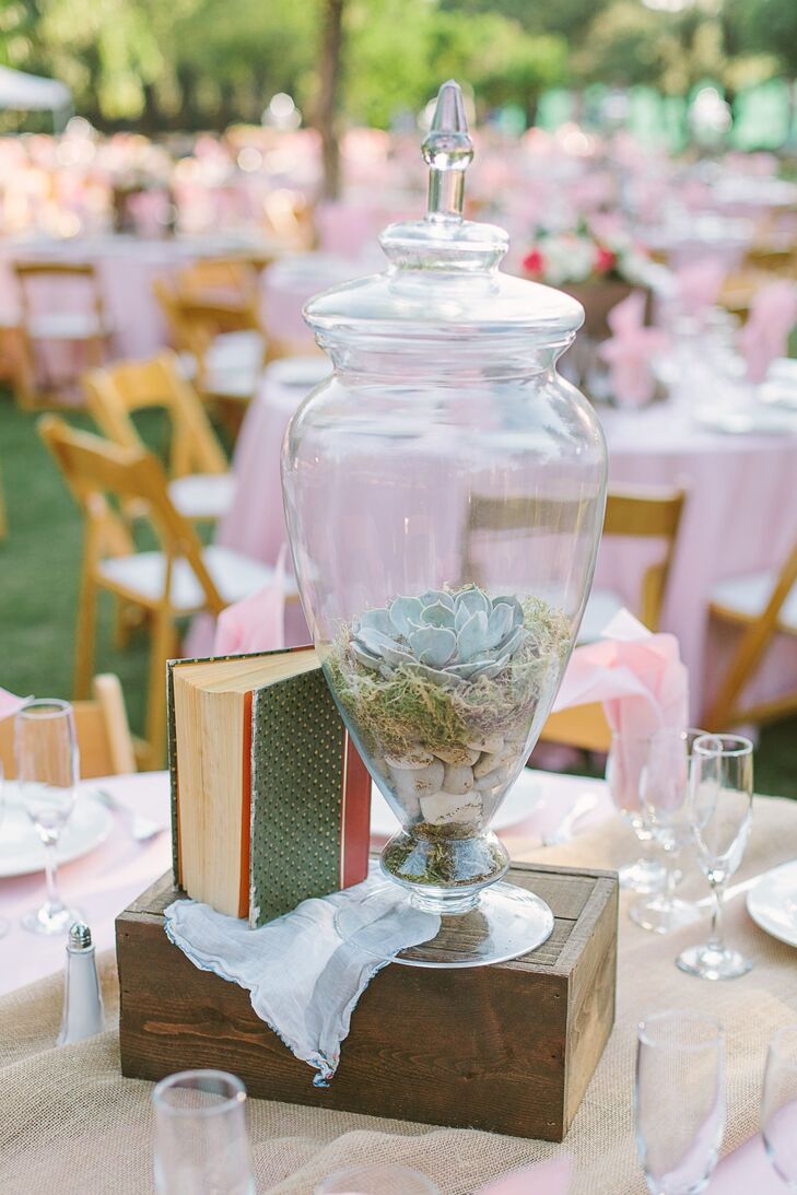 Sweet Memories Flowers created unique rustic centerpieces for Madison and Brent's reception. Large ginger jars holding succulents and moss sat atop vintage wooden boxes. Accent pieces included antique books and handkerchiefs.