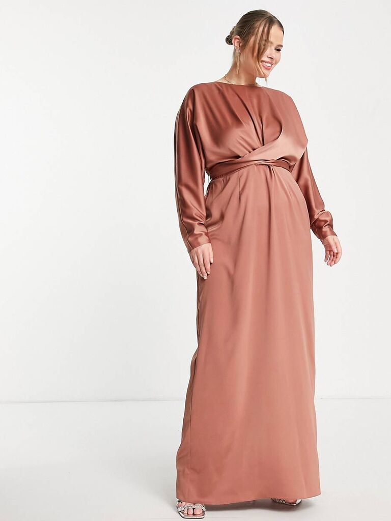Model wears a long sleeved pink silk gown. 