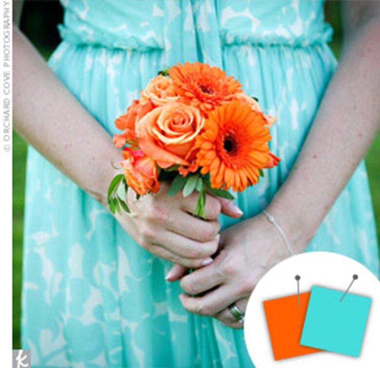 bridesmaid in an aqua dress carrying orange bouquet