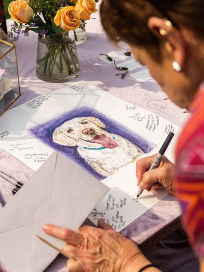 Guest writing on guest book sign with picture of dog
