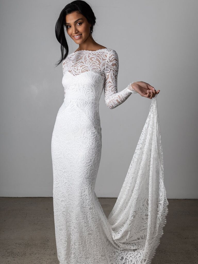 Model wears a long sleeved lace gown by Grace Loves Lace. 