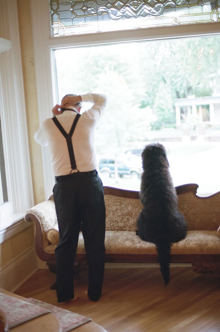 The groom, in a Heimie's Haberdashery tuxedo, gets ready while the couple's sweet dog keeps him company.