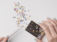person's hand with loose gemstones