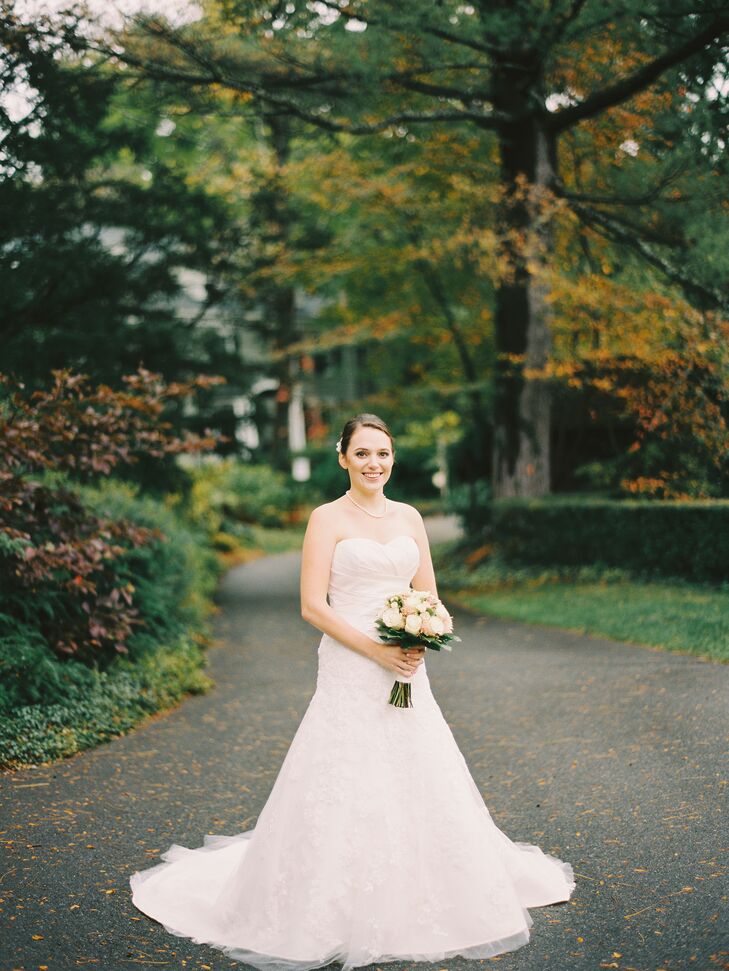 "My wedding dress was a strapless fit-and-flare gown with a sweetheart neckline," says Emily. "It was pleated at the top with lace on the skirt portion.  I wore simple white satin flats and my mom's cathedral length veil."