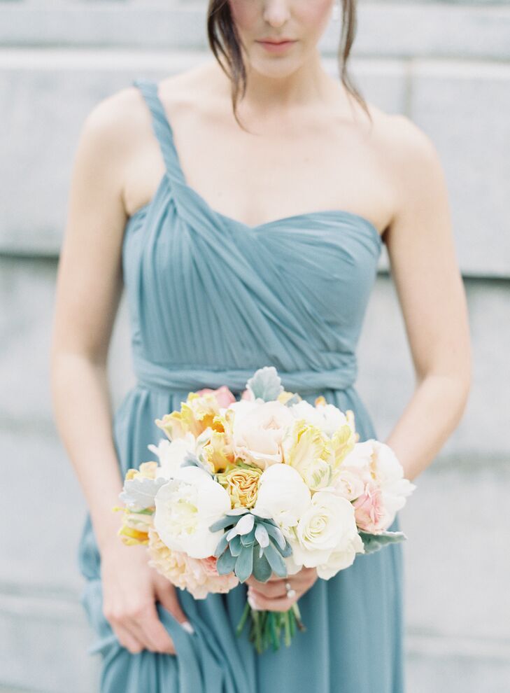 To really make the bridesmaids’ bouquets pop, The Special Events Florist created the perfect balance of bright and muted hues. Lush garden roses, peonies and tulips in shades of peach, pink and white allowed the arrangements to stand out against the backdrop of the girls’ grayish-blue gowns, while elements like dusty miller and succulents complemented the hue of the Jenny Yoo designs, helping to keep their look feeling cohesive.