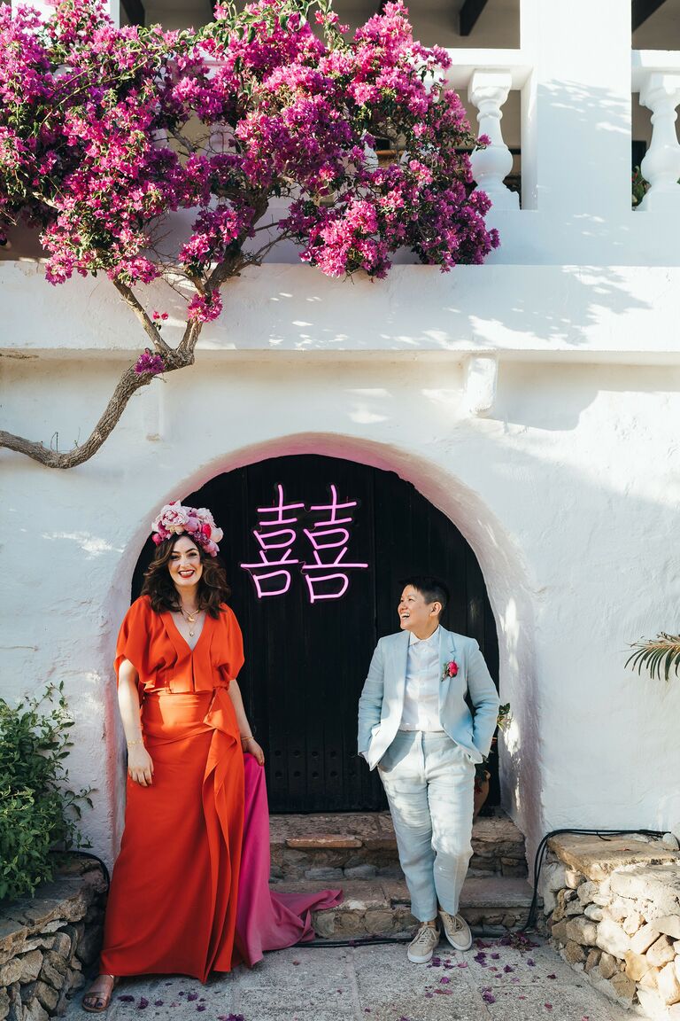 Couple posing in front of custom neon sign