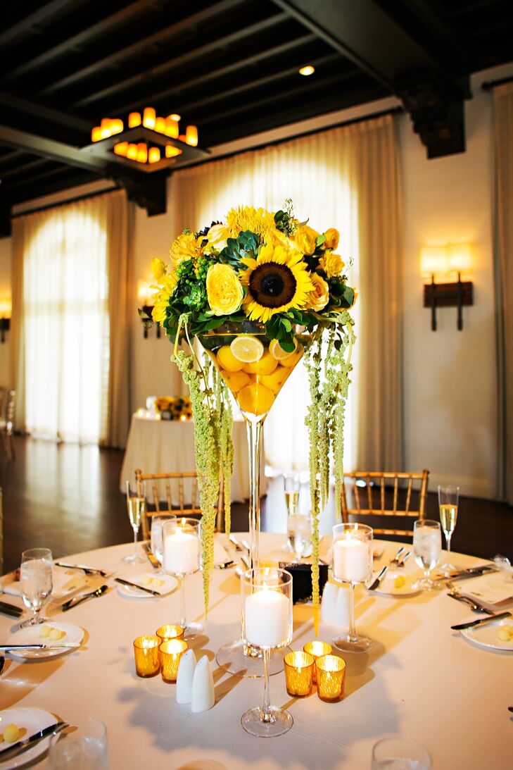 The couple decorated their reception tables with colorful arrangements of yellow garden roses, sunflowers and succulents above floating lemons.