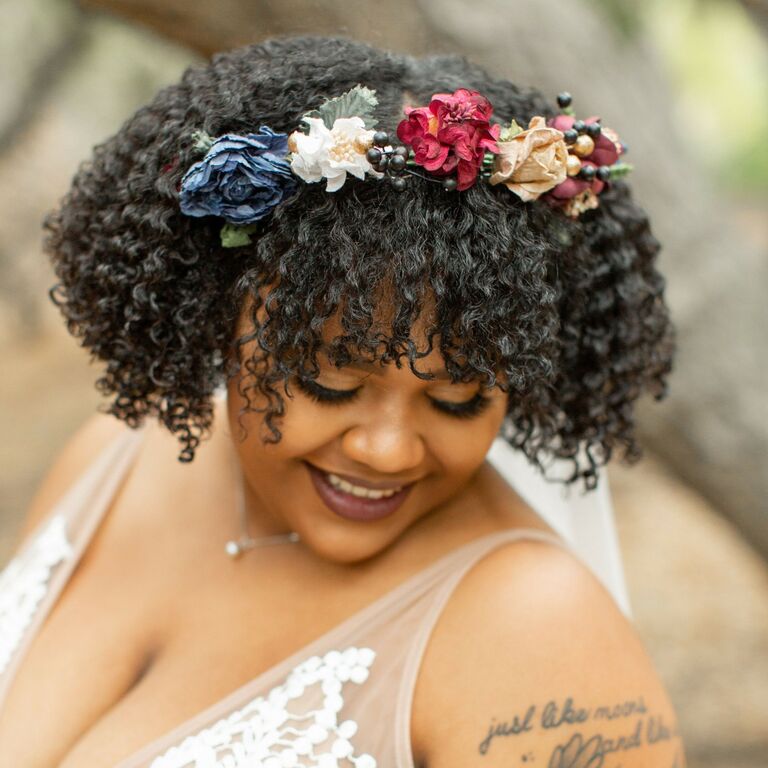 Smiling bride shows off her beautiful hairstyle adorned with a whimsical flower crown. 