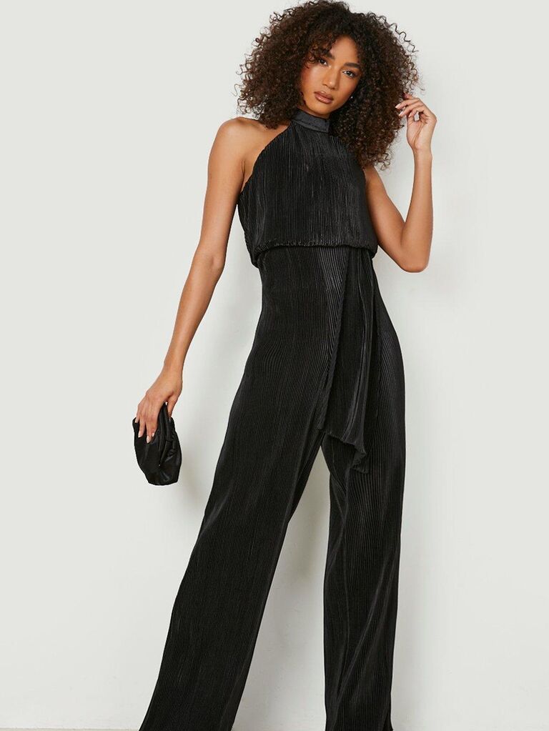 Model wearing an elegant halter-neck jumpsuit in black