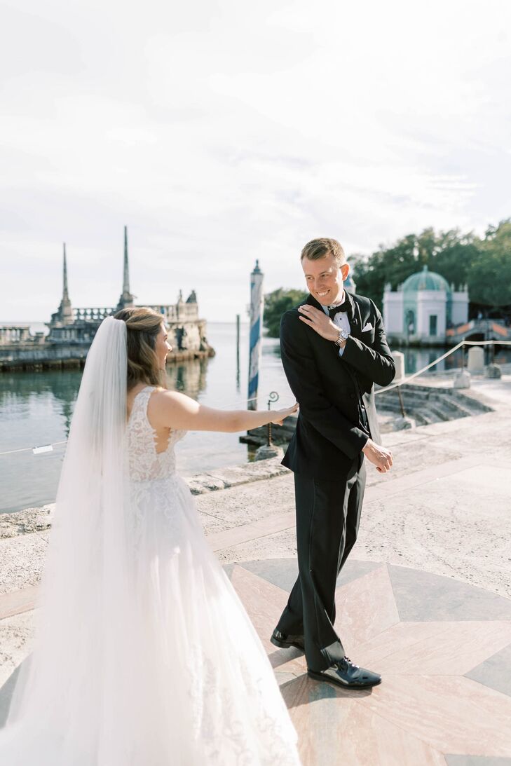 Bride Tapping Groom on Shoulder During Waterfront First Look at Waterfront Estate