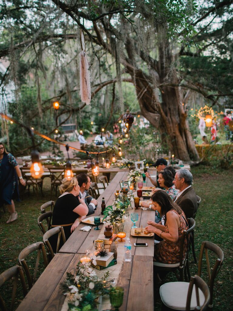 wedding guests seated at long reception table at garden venue