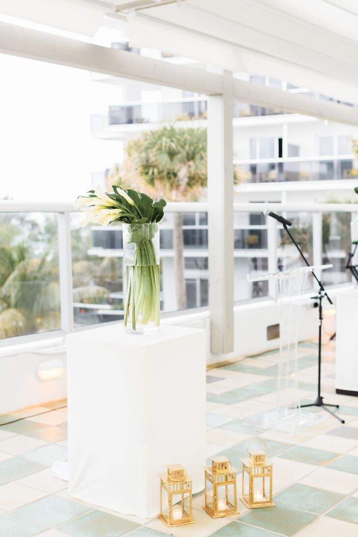 The ceremony was held on the upper-floor patio of the Confidante in Miami Beach, Florida. "We wanted the ocean view to be the focal point, so we kept the decor simple and sleek," Wes says. "We went with a white runner down the aisle lined with vintage-inspired gold lanterns. At the altar, we had two large calla lily arrangements."