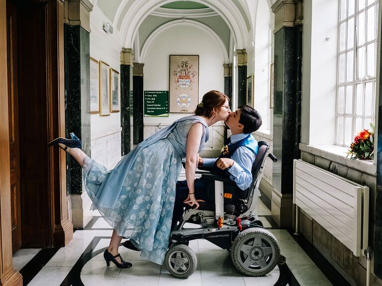 Bride kissing groom with foot up