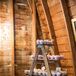 The one-tier cake and cupcakes were displayed on a vintage wooden table. To make more space, Hannah and Caleb set up a rustic wooden ladder on top of the table to make little shelves for the desserts. They wanted this area of the barn to be a little more romantic, so they hung a crystal chandelier next to the display.