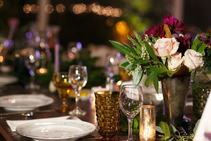 The farm tables hosted mismatched china flatware and colorful goblets at each place setting. Centerpieces included winter flower arrangements in rich purple, red, blush and white hues with greenery, metallic vases and mercury glass votives.