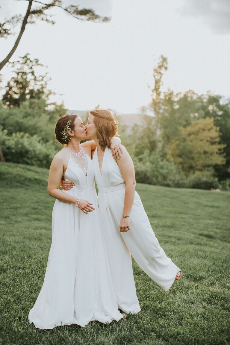 Same-sex couple wearing white wedding outfits
