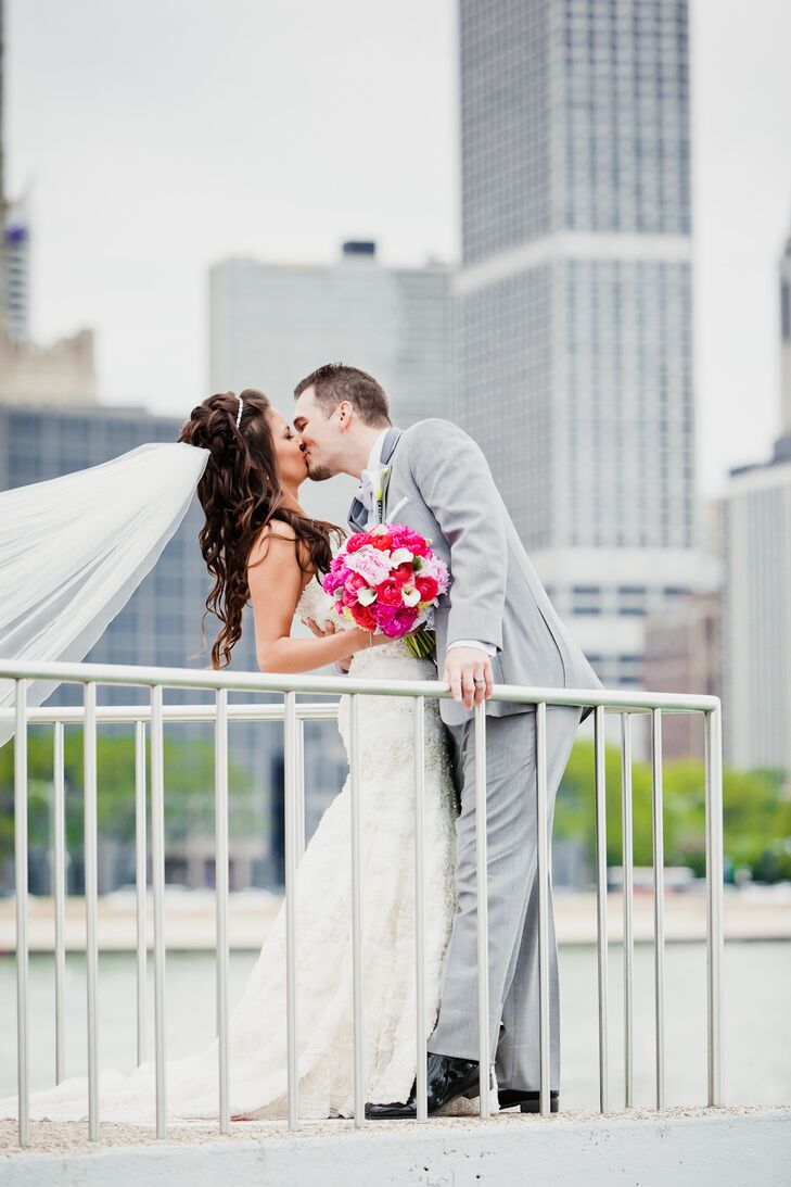 Groom Kisses Bride with Pink Bouquet and Cathedral Veil