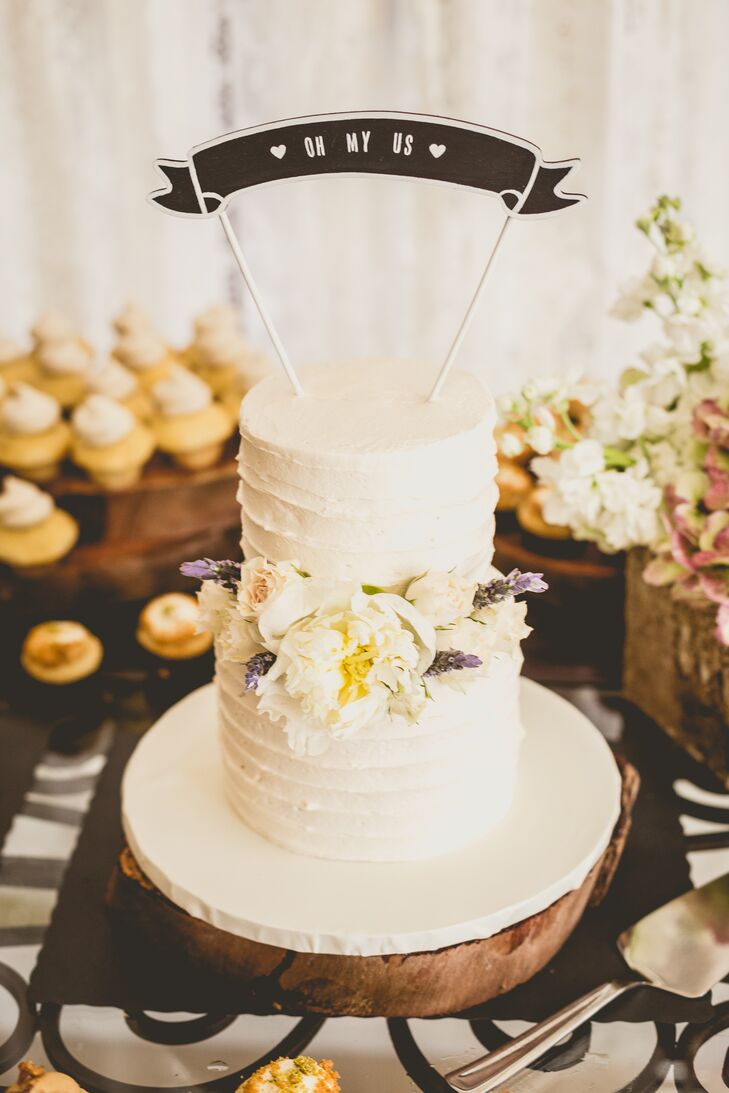 On top of personalized mini cupcakes, Roxy and Rodney also served a two-tier, ivory buttercream confection from Drea's Desserts. The center was highlighted with a white peony to match their arrangements as well as white roses and lavender from Flowers International Events.