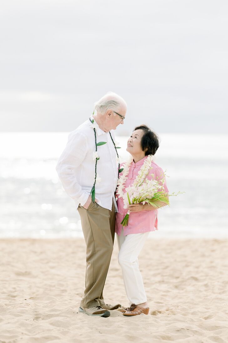 Bride in Traditional Pink Tang Suit and Groom in Casual Attire With Leis at Vow Renewal