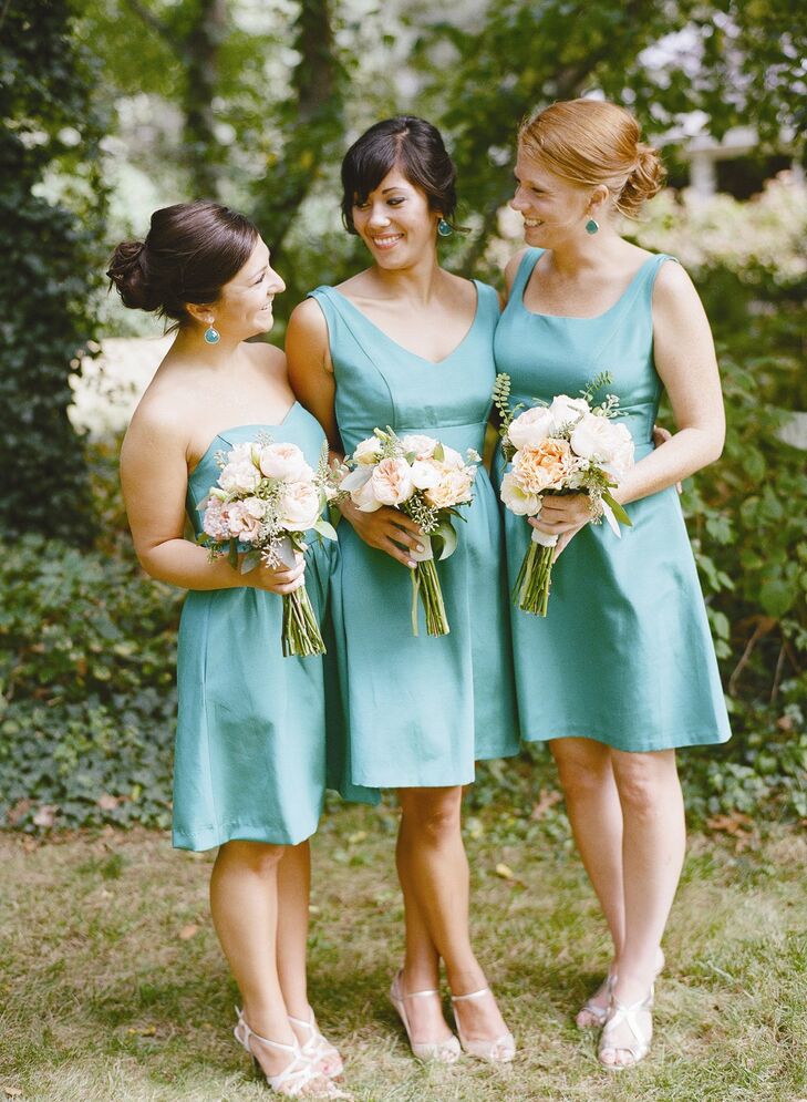 Caitlin’s bridesmaids wore knee-length gowns in the same teal-colored fabric with the neckline of their choice. They carried Juliet roses, ranunculus and dahlias in soft shades of pink and orange to complement their dresses.