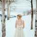 Suzi wore designer Catherine Deane’s Onyx gown for her winter nuptials. She loved the flowing tulle skirt and the white lace detailing on the back. She completed her look with a champagne satin belt and a wintery green and gold flower crown.