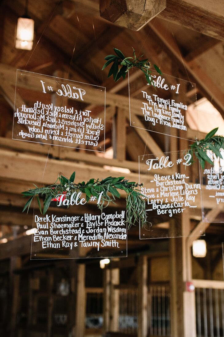 Midway through the planning process, Hope decided that the decor was in need of a few modern touches. “Our seating signage was a random idea of mine that I really didn’t think would become a reality, but with Ultra Pom and Jonnelle of Events by Elle, it did,” Hope says. “I’m still obsessed.” The names of guests were hand lettered onto squares of clear acrylic material, which were then draped in garlands of greenery and suspended from the rafters of the barn.