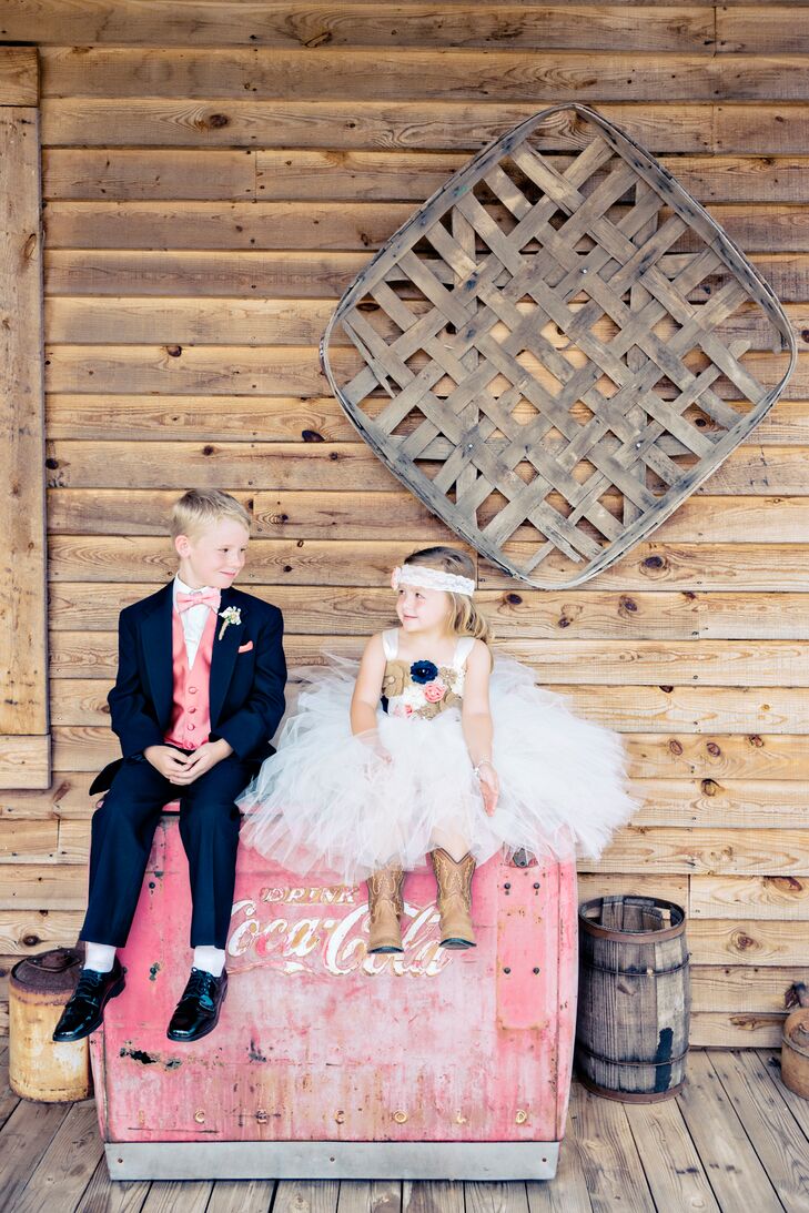 Samantha and Chris's little attendants dressed the part, and they were too cute! The flower girl wore a tulle dress with burlap, coral and navy floral appliques, a lace headband and cowboy boots. The ring bearer dressed up in a navy suit with a coral vest and bow tie.