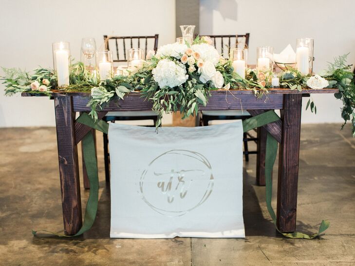 Rustic Sweetheart Table with Monogrammed Sign and Lush Floral Arrangement