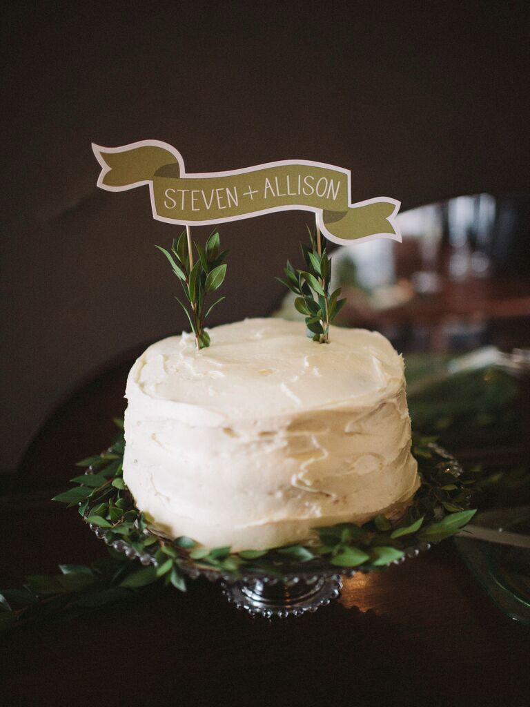 buttercream one tier wedding cake with custom banner-style cake topper with couple's names