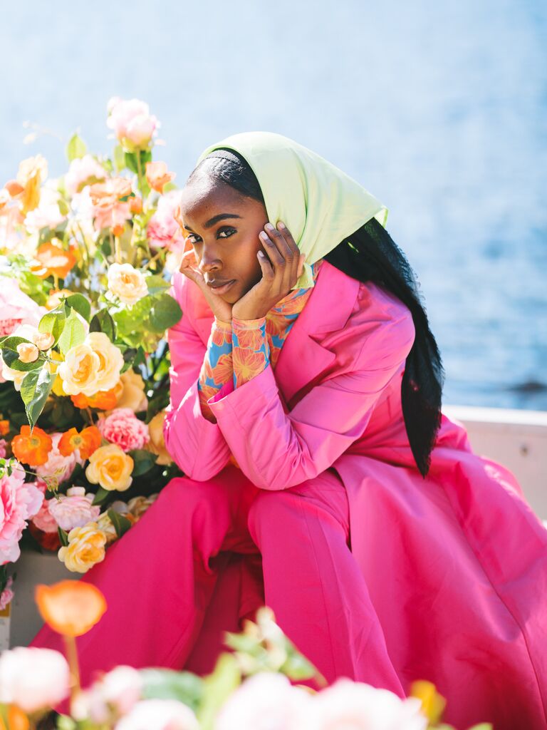 Influencer in pink-and-green outfit posing in boat
