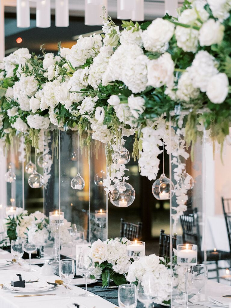 modern white wedding centerpieces on tall clear acrylic stands with hanging votive candles