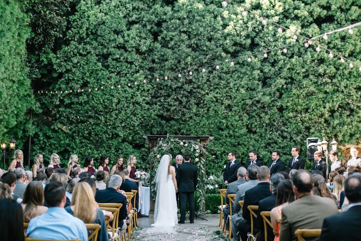 A living wall of green trees created a natural backdrop for the intimate courtyard ceremony at Franciscan Gardens in San Juan Capistrano, California.