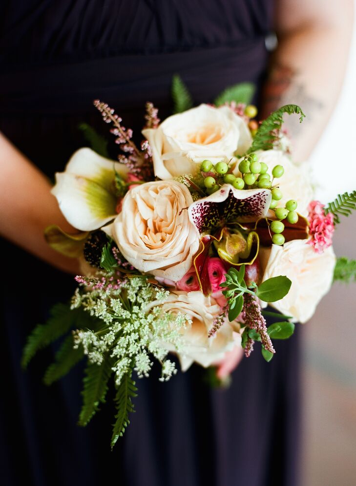 The bridesmaids carried smaller versions of Tessa's bouquet. Martha's Gardens included roses, orchids, Queen Anne's lace, astilbes, ranunculus and hypericum berries in their arrangements for a textured, rustic look.
