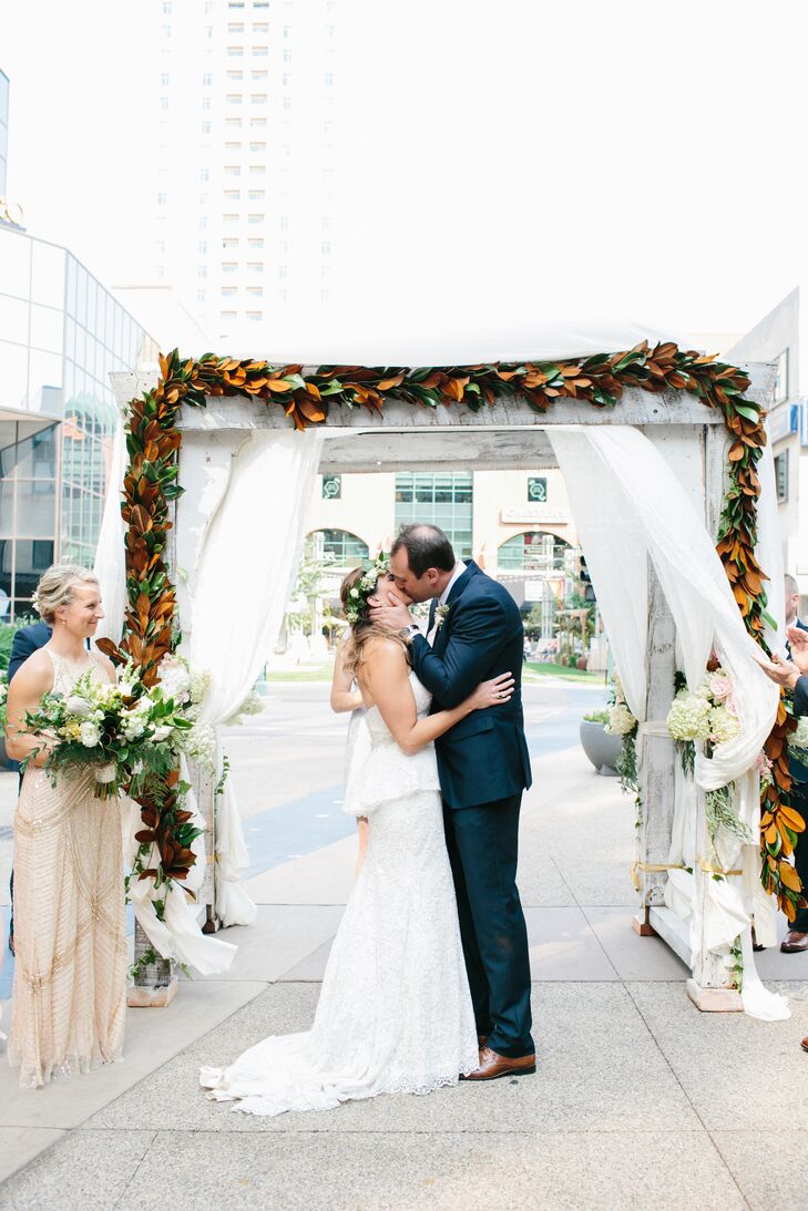 Claire and Rob got married in Peace Plaza in downtown Rochester, Minnesota. "Rochester is the smallest city I’ve ever lived in, and I really wanted to capture as much of an urban feel as we could with our ceremony and reception venue," Claire says. They were sure to bring a modern botanical feel to the space with golden magnolia leaves and lush, white flower arrangements.