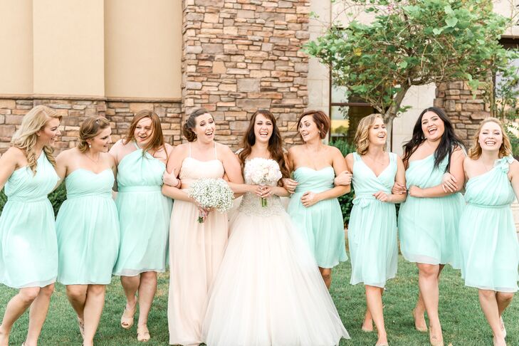 Brittney's bridesmaids wore knee-length chiffon dresses in mint blue with various necklines. Her maid of honor stood apart in a floor-length gown in blush.