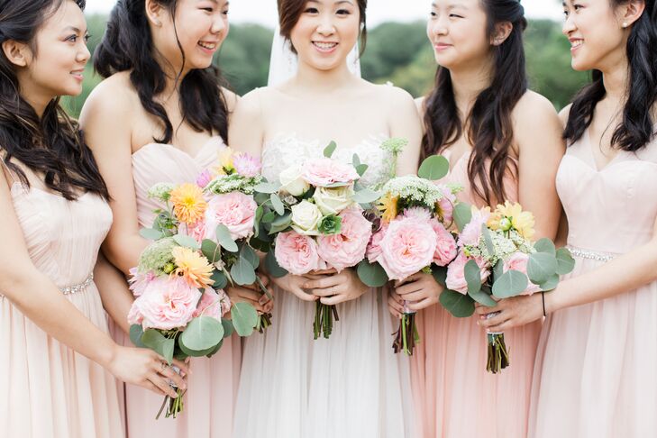 The bridesmaids wore different blush dresses, bringing their looks together with the same lush bouquets from Adel Strauss. Each garden-style arrangement overflowed with greenery, Queen Anne’s lace, pink garden roses and pastel dahlias. The designs resembled mini versions of Priscilla’s own bouquet.