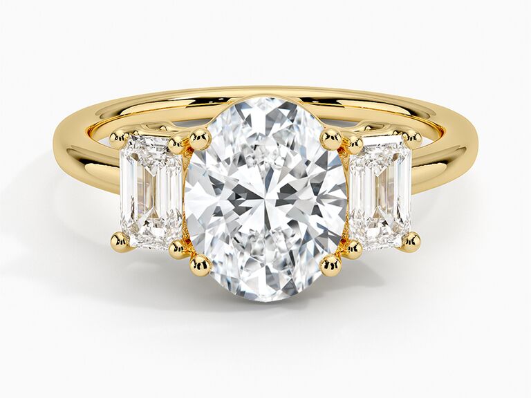Two emerald-cut diamonds alongside an oval diamond center stone