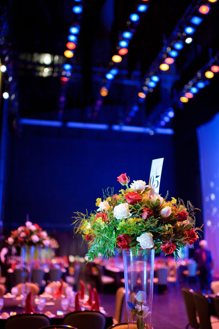Centerpieces at the reception were arranged on tall glass vases. They included red and white roses, yellow sedums and greens.