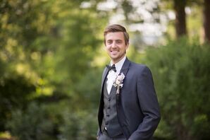 Groom in a Dark Gray Tuxedo With a Black Bow Tie and White Boutonniere