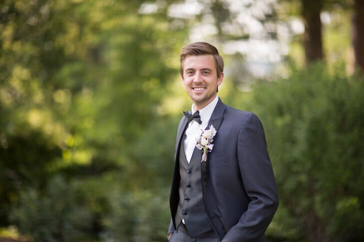 Nate wore a dark gray tuxedo with a black bow tie and vest. His white boutonniere consisted of white roses and dusty miller.