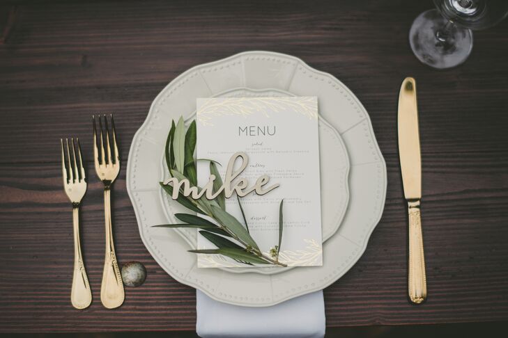 Gold flatware accompanied vintage-style ivory plates at each table setting, along with personalized name plates that Crystal had cut from wood.