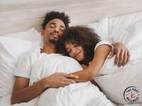 Couple cuddling on one of the best mattress for couples