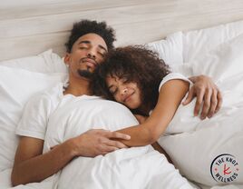 Couple cuddling on one of the best mattress for couples