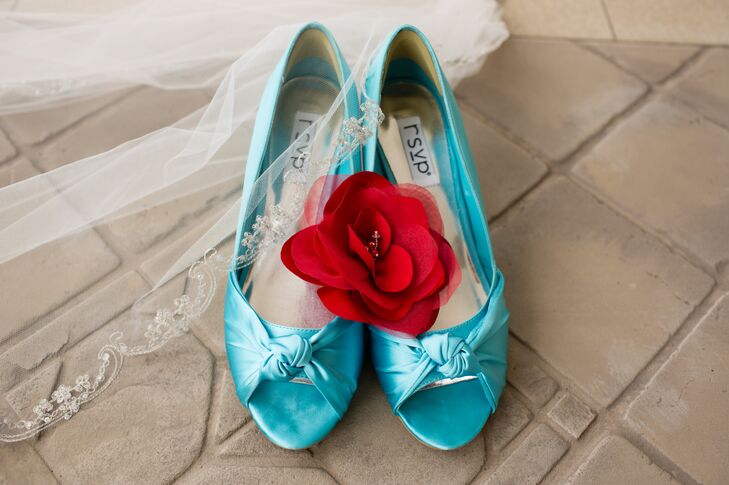 Teal open toed shoes worn by the bride were decorated with a red rose with a veil draped over the corner.